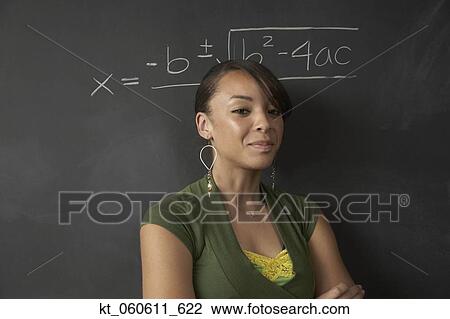Stock Image - African female student next to math problem on blackboard. Fotosearch
