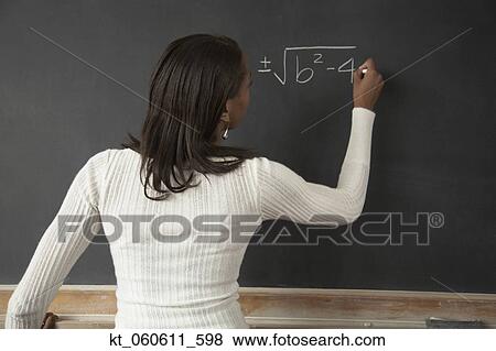 Stock Photo - African female student writing on blackboard. Fotosearch