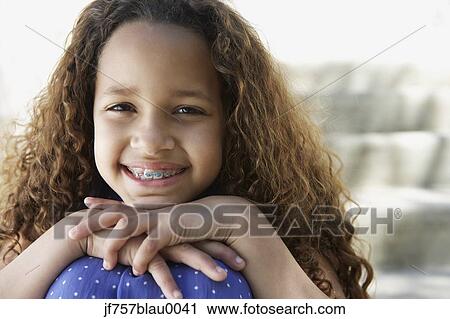 African girl with braces leaning chin on knees outdoors View Large Photo Image Stock Image - African girl with braces leaning chin on knees outdoors. Fotosearch
