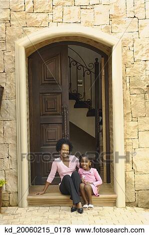 African mother and daughter sitting on doorstep View Large Photo Image Stock Photo - African mother and daughter sitting on doorstep. Fotosearch