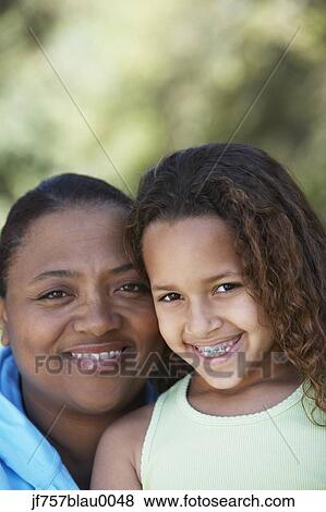 Stock Photo - African mother and daughter with braces smiling. Fotosearch