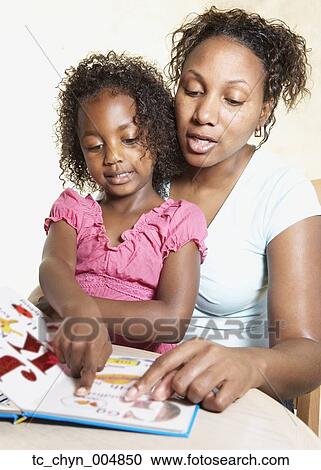 Stock Image - African mother reading to young daughter. Fotosearch