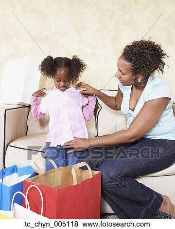 African mother showing young daughter new clothes View Large Photo Image Stock Photo - African mother showing young daughter new clothes. Fotosearch