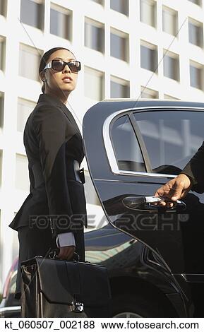 Stock Photo - Asian businesswoman getting into town car. Fotosearch