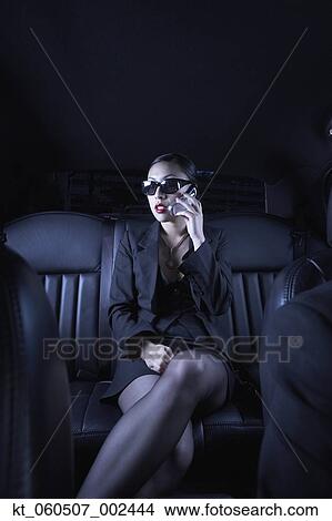 Asian businesswoman using cell phone in back seat of car View Large Photo Image Picture - Asian businesswoman using cell phone in back seat of car. Fotosearch