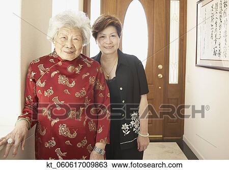 Asian mother and adult daughter smiling indoors View Large Photo Image Stock Image - Asian mother and adult daughter smiling indoors. Fotosearch
