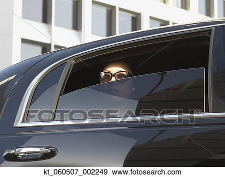 Stock Photo - Asian woman in limousine with window part of the way down. Fotosearch