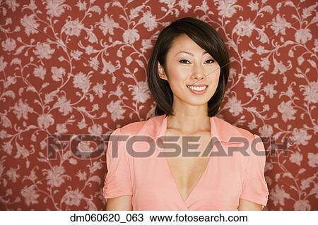Asian woman smiling in front of floral wallpaper View Large Photo Image Stock Image - Asian woman smiling in front of floral wallpaper. Fotosearch