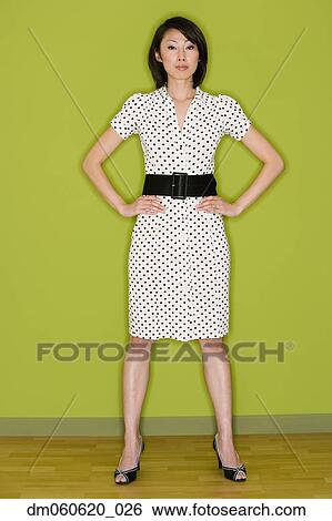Stock Photograph - Asian woman standing with hands on hips. Fotosearch