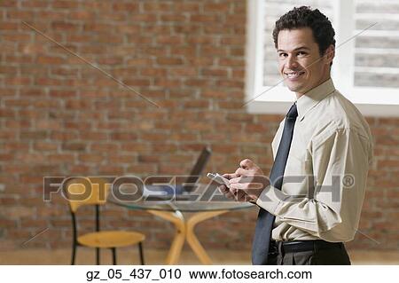 Businessman using PDA indoors View Large Photo Image Stock Image - Businessman using PDA indoors. Fotosearch