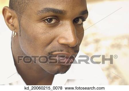 Stock Photo - Close up of African man wearing earring. Fotosearch