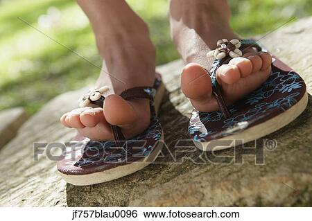 Close up of girl's feet in flip flops outdoors View Large Photo Image Stock Photograph - Close up of girl's feet in flip flops outdoors. Fotosearch