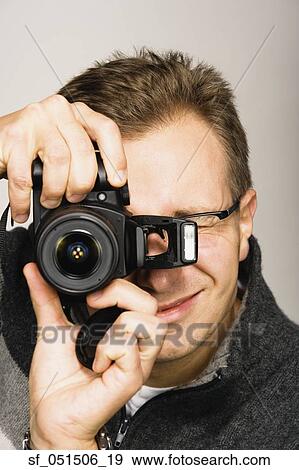 Close up studio shot of man using camera View Large Photo Image Stock Photo - Close up studio shot of man using camera. Fotosearch