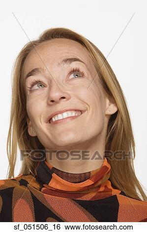 Close up studio shot of woman smiling and looking up View Large Photo Image Stock Photograph - Close up studio shot of woman smiling and looking up. Fotosearch