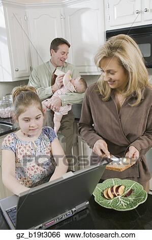 Family in kitchen at breakfast time View Large Photo Image Stock Photograph - Family in kitchen at breakfast time. Fotosearch
