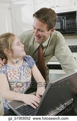 Father and daughter using laptop in kitchen View Large Photo Image Stock Image - Father and daughter using laptop in kitchen. Fotosearch