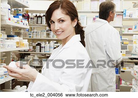 Stock Photograph - Female and male pharmacists in pharmacy. Fotosearch