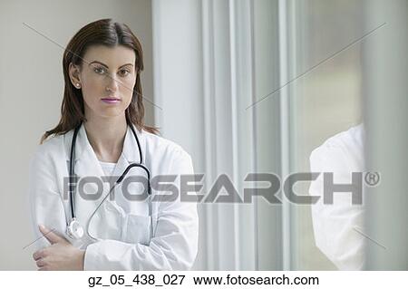Stock Photo - Female doctor standing next to window indoors. Fotosearch