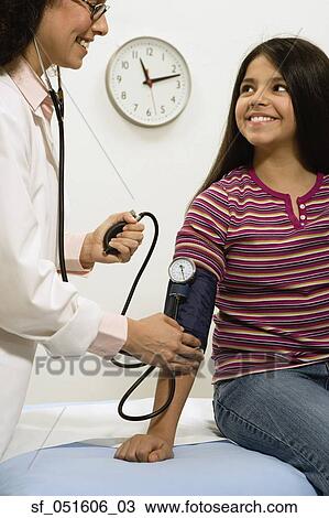 Female doctor taking young female patient's blood pressure View Large Photo Image Stock Image - Female doctor taking young female patient's blood pressure. Fotosearch