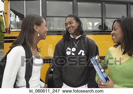 Stock Photo - Group of African friends talking next to school bus. Fotosearch