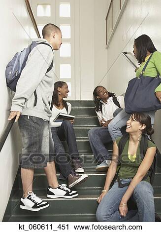 Stock Image - Group of friends sitting on stairs at school. Fotosearch