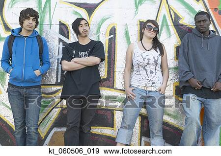 Group of young adults leaning against graffitied wall View Large Photo Image Stock Photo - Group of young adults leaning against graffitied wall. Fotosearch