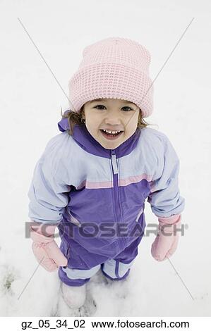 Stock Image - High angle view of young girl in snowsuit outdoors. Fotosearch