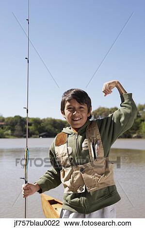 Stock Image - Hispanic boy holding fishing pole outdoors. Fotosearch