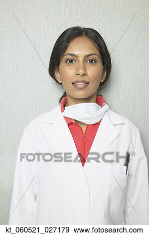 Indian female dentist in lab coat and surgical mask View Large Photo Image Stock Photo - Indian female dentist in lab coat and surgical mask. Fotosearch