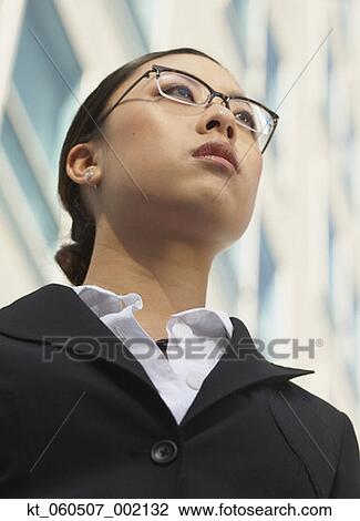 Stock Image - Low angle view of Asian businesswoman outdoors. Fotosearch