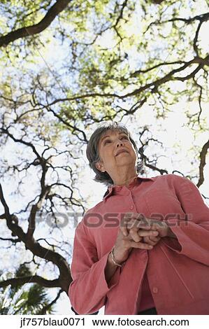 Stock Image - Low angle view of senior woman outdoors. Fotosearch