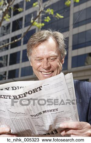 Middle-aged businessman reading newspaper outdoors View Large Photo Image Stock Image - Middle-aged businessman reading newspaper outdoors. Fotosearch