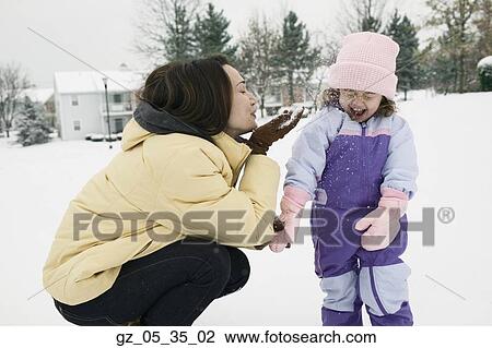 Mother and young daughter playing with snow View Large Photo Image Stock Image - Mother and young daughter playing with snow. Fotosearch