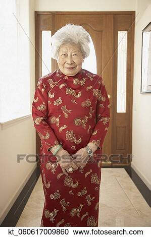 Stock Image - Senior Asian woman in traditional dress smiling. Fotosearch