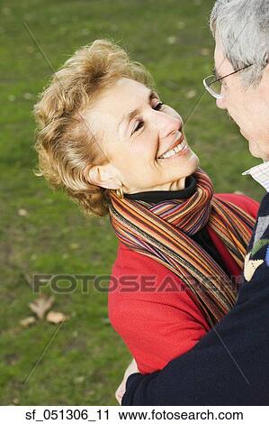 Stock Image - Senior couple smiling at each other outdoors. Fotosearch
