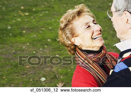 Stock Image - Senior couple smiling at each other outdoors. Fotosearch