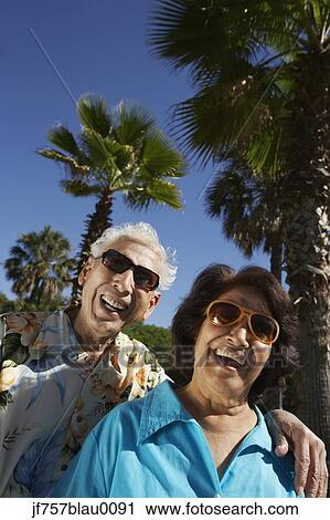 Stock Image - Senior Hispanic couple laughing outdoors. Fotosearch