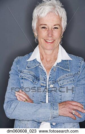 Stock Image - Senior woman in denim jacket smiling. Fotosearch