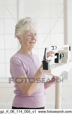 Senior woman weighing self on scale View Large Photo Image Stock Image - Senior woman weighing self on scale. Fotosearch