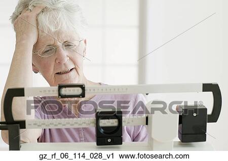 Senior woman weighing self on scale View Large Photo Image Stock Image - Senior woman weighing self on scale. Fotosearch