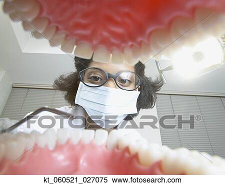 Stock Photography - Shot from mouth looking out at African female dentist. Fotosearch