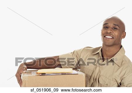 Studio shot of African delivery man with package View Large Photo Image Stock Photo - Studio shot of African delivery man with package. Fotosearch