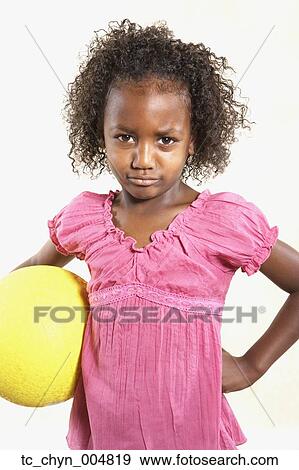 Stock Photo - Studio shot of African girl holding ball. Fotosearch