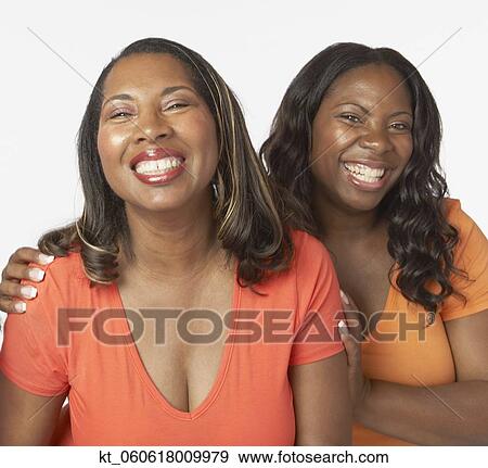 Stock Photo - Studio shot of African mother and adult daughter smiling. Fotosearch