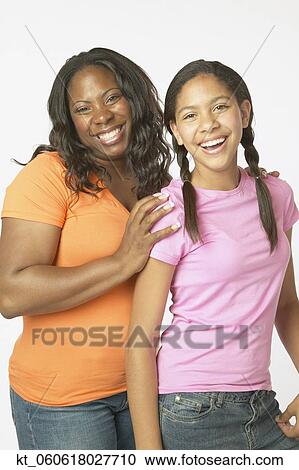 Stock Image - Studio shot of African mother and daughter smiling. Fotosearch