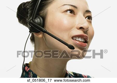 Studio shot of Asian woman wearing headset View Large Photo Image Stock Photo - Studio shot of Asian woman wearing headset. Fotosearch