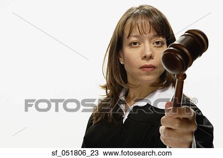 Stock Image - Studio shot of Hispanic female judge holding gavel. Fotosearch
