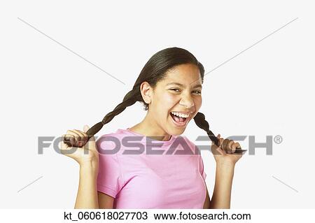 Studio shot of Hispanic girl holding her pigtails View Large Photo Image Stock Image - Studio shot of Hispanic girl holding her pigtails. Fotosearch
