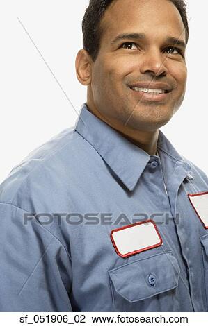 Stock Image - Studio shot of Hispanic maintenance man smiling. Fotosearch