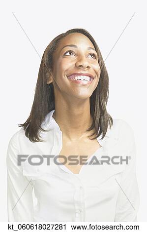 Studio shot of young African woman smiling and looking up View Large Photo Image Stock Image - Studio shot of young African woman smiling and looking up. Fotosearch